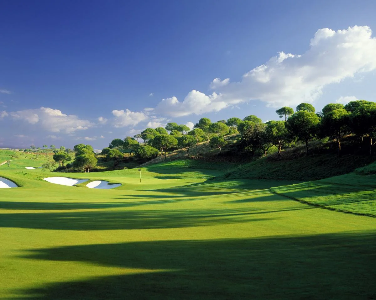 Monte Rei fairway and white sand bunkers beneath a blue sky