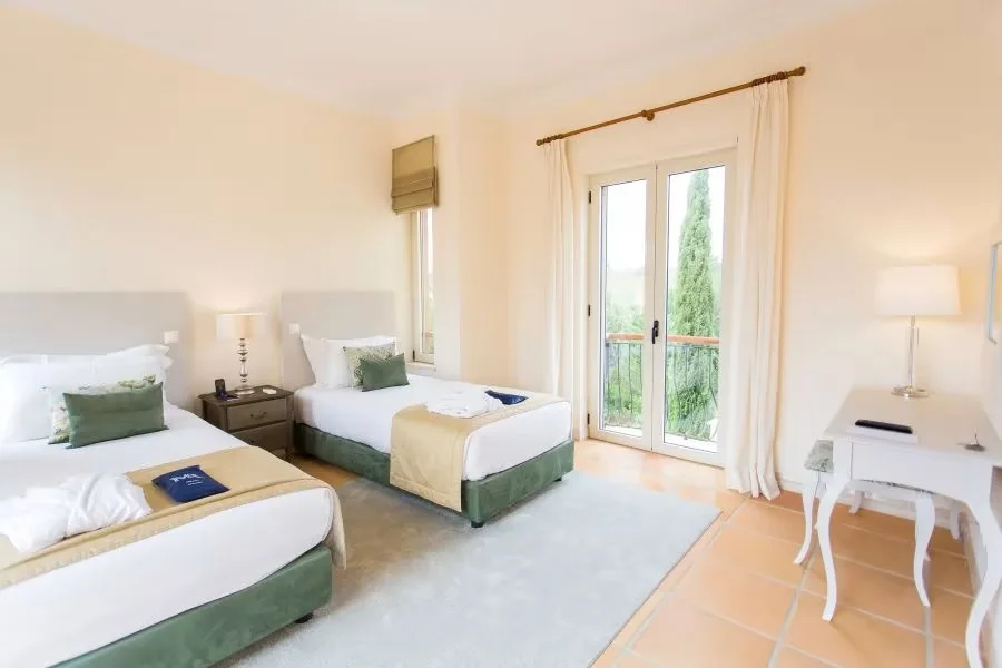 Two single beds in a bright Monte Rei linked villa bedroom